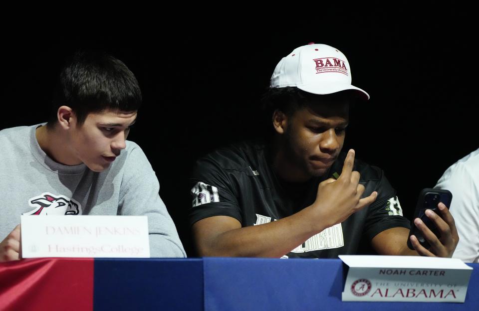 Centennial seniors Damien Jenkins (left) and Noah Carter (right) pose for Carter's livestream during a Signing Day Ceremony at Centennial High School in Peoria on Feb. 7, 2024.