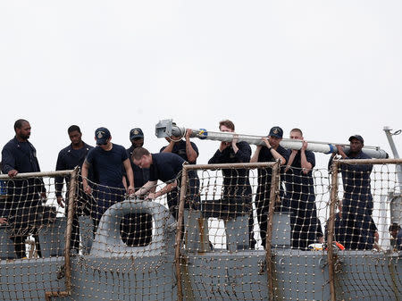 Personnel work on the U.S. Navy guided-missile destroyer USS John S. McCain after a collision, in Singapore waters August 21, 2017. REUTERS/Ahmad Masood