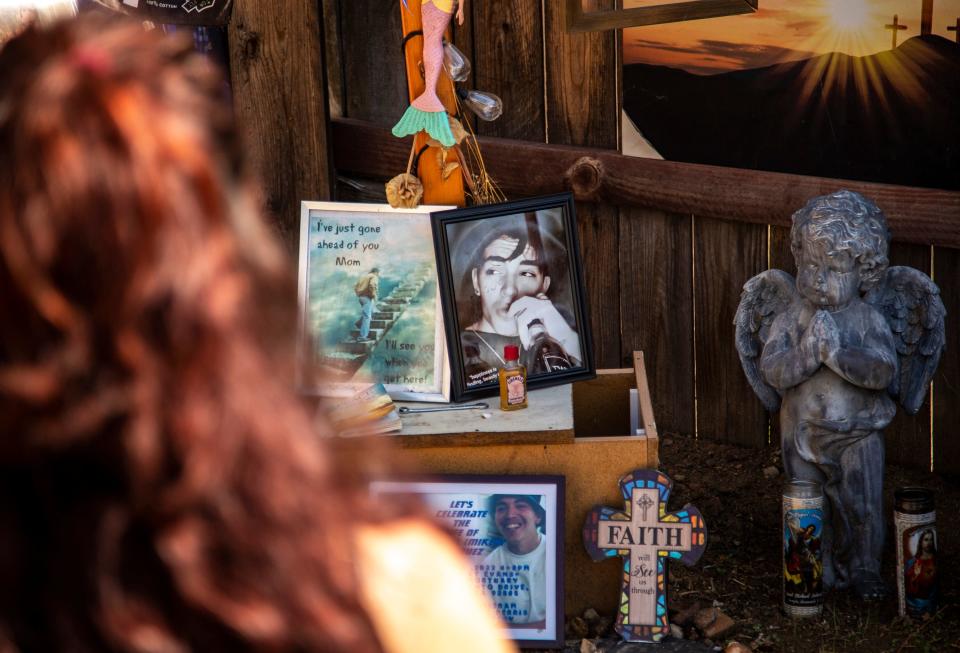 Kathy Nigro sits on a bench in her backyard in front of a memorial displaying photos and other reminders of her son, Michael Vasquez, in Menifee, Calif., Wednesday, Sept. 14, 2022. Vasquez died in jail on May 26, 2022, in the custody of the Riverside County Sheriff's Department.