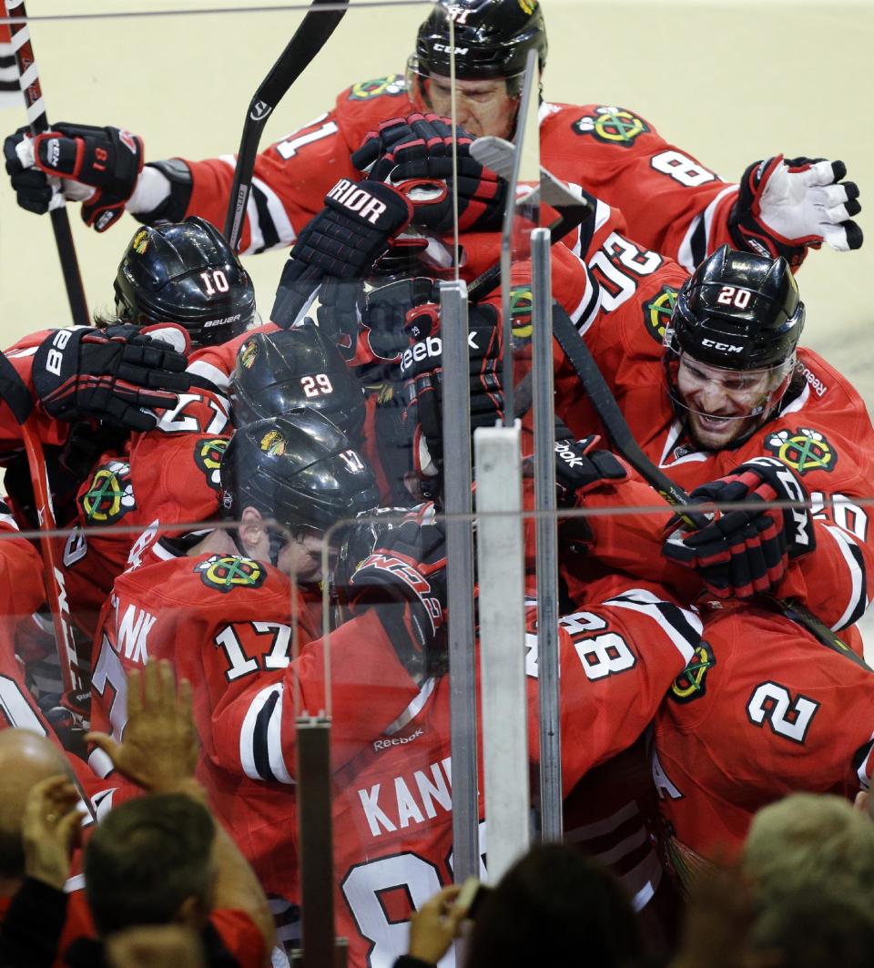 Chicago Blackhawks' Patrick Kane (88) celebrates with teammates after scoring the game-winning goal during overtime period in Game 4 of a first-round NHL hockey playoff series against the St. Louis Blues in Chicago, Wednesday, April 23, 2014. The Blackhawks won 4-3 in overtime. (AP Photo/Nam Y. Huh)