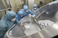 Employees work on the production line of an antimalarial drug that Chinese officials said has curative effect on the novel coronavirus disease, at a pharmaceutical company in Nantong