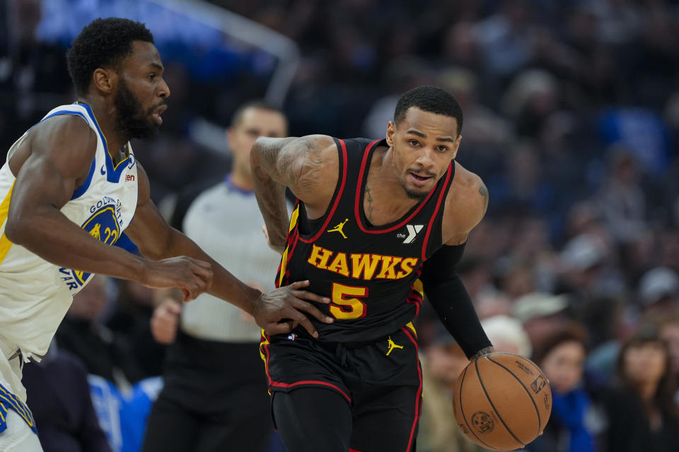 Atlanta Hawks guard Dejounte Murray, right, moves the ball while defended by Golden State Warriors forward Andrew Wiggins during the first half of an NBA basketball game, Wednesday, Jan. 24, 2024, in San Francisco. (AP Photo/Godofredo A. Vásquez)