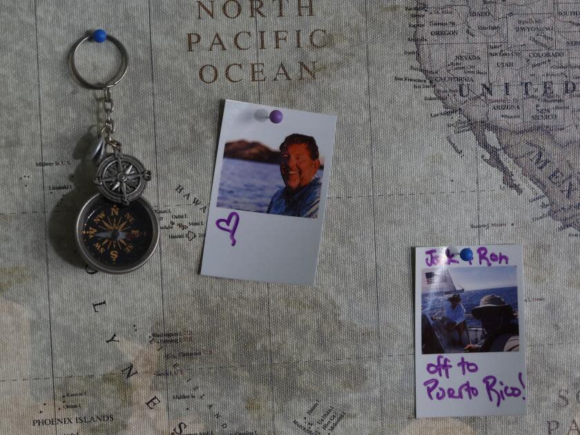 Photographs and compass keychain are pinned to a map