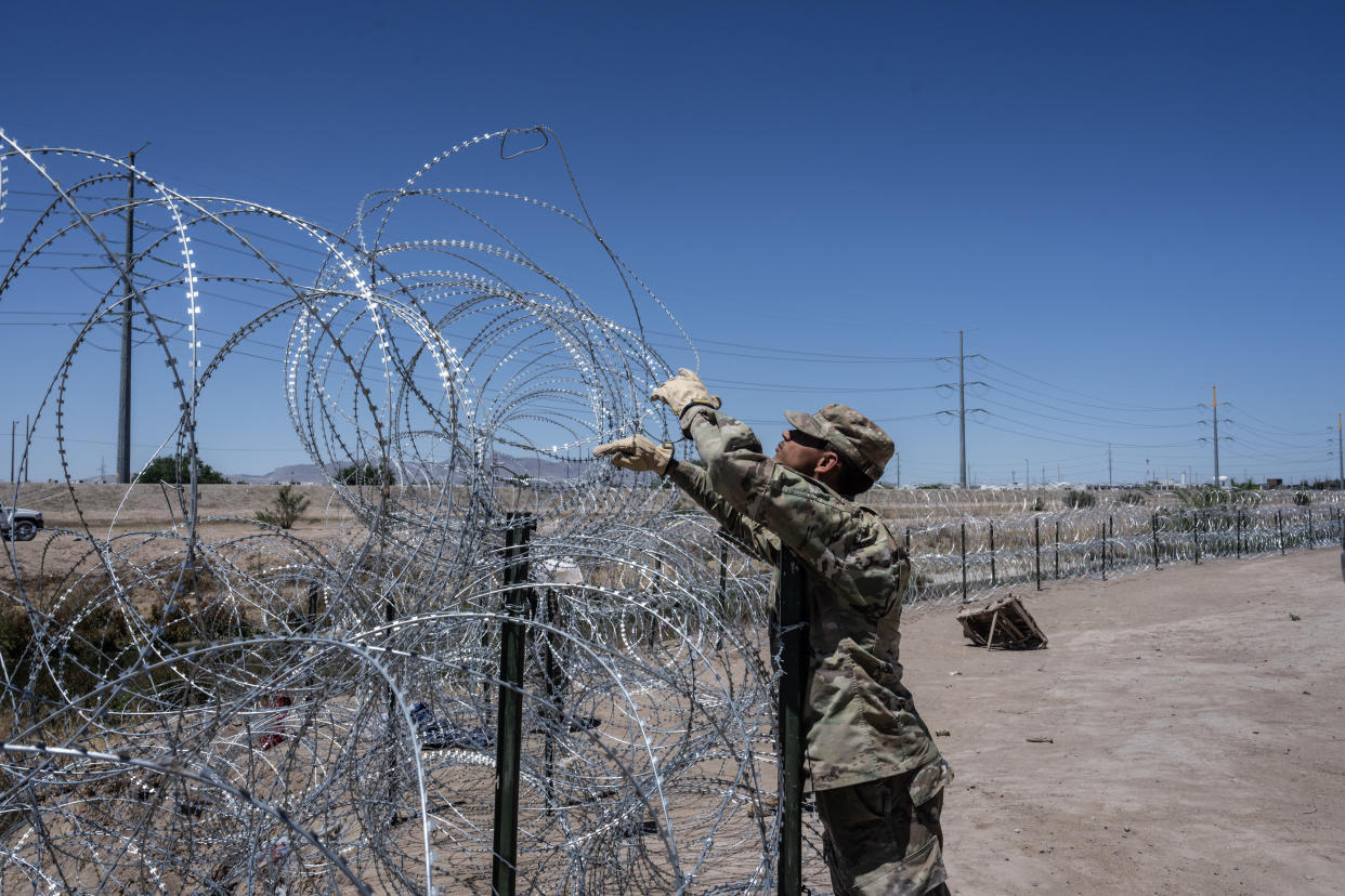 Un soldado de la Guardia Nacional de Texas agrega una capa de alambre de concertina a lo largo de la frontera con México en El Paso, Texas, el 8 de mayo de 2023. (Todd Heisler/The New York Times)