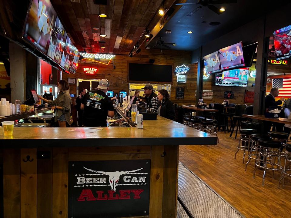 The bar at Beer Can Alley splits the room in two. Customers can order from either side.