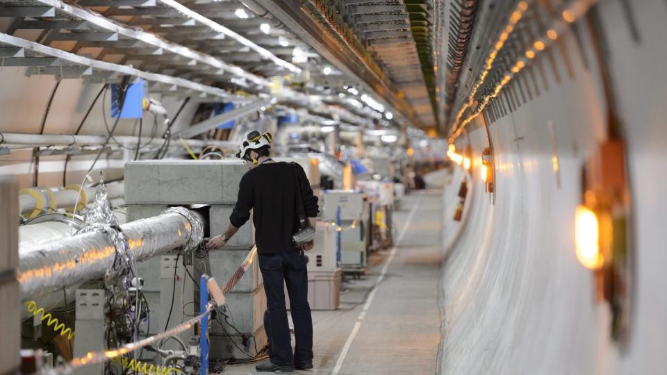 Ein Techniker arbeitet am Cern in einem Tunnel für den Teilchenbeschleuniger LHC in Meyrin bei Genf. Foto: Laurent Gillieron/KEYSTONE