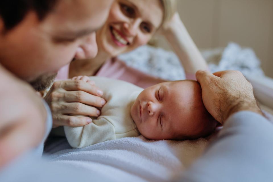 Close-up of parents cuddling their newborn son.