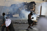 Anti-government protesters clash with security forces as they show support for an apparent mutiny by a national guard unit in the Cotiza neighborhood of Caracas, Venezuela, Monday, Jan. 21, 2019. (AP Photo/Fernando Llano)