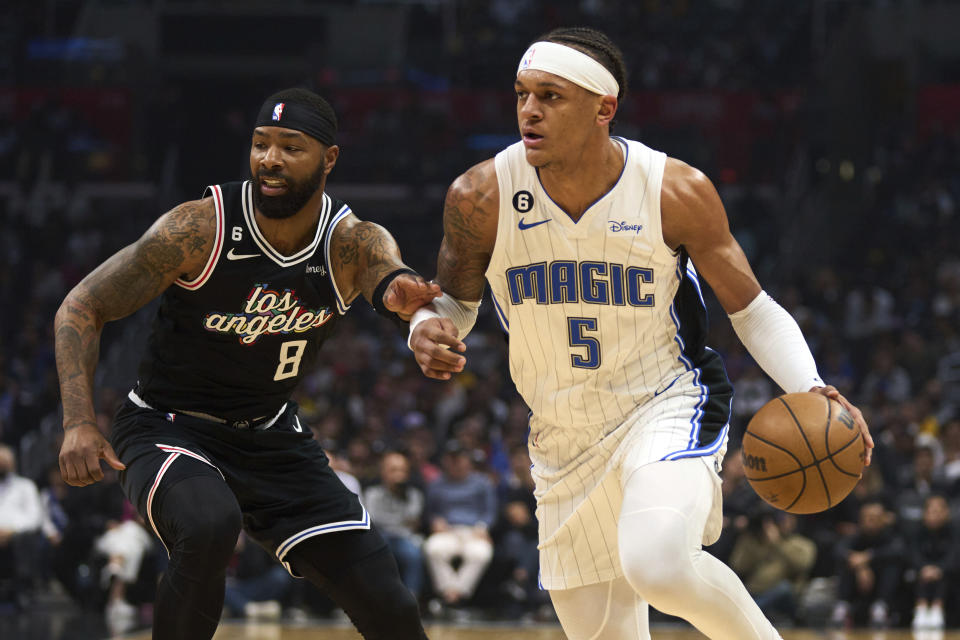 Orlando Magic forward Paolo Banchero (5) drives down the court past Los Angeles Clippers forward Marcus Morris Sr. (8) during the first half of an NBA basketball game Saturday, March 18, 2023, in Los Angeles. (AP Photo/Allison Dinner)