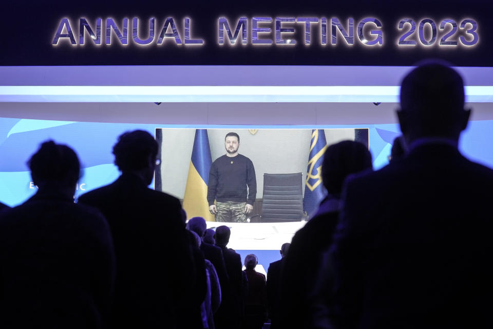 President Volodymyr Zelenskyy of Ukraine is seen on a video screen, holding a minute of silence with participants at the World Economic Forum in Davos, Switzerland, for the victims of a helicopter crash in Ukraine, where Minister of Internal Affairs Denys Monastyrsky died among others on Wednesday, Jan. 18, 2023. The annual meeting of the World Economic Forum is taking place in Davos from Jan. 16 until Jan. 20, 2023. (AP Photo/Markus Schreiber)