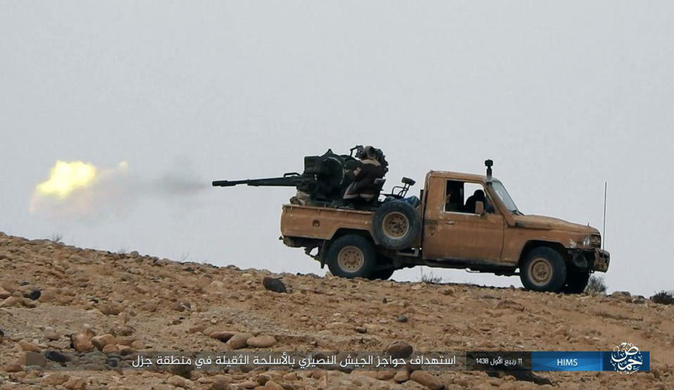 This image posted online on Saturday, Dec. 10, 2016, by supporters of the Islamic State militant group on an anonymous photo sharing website, purports to show a gun-mounted vehicle operated by the group firing at Syrian troops north of Palmyra city, in Homs, Syria. Syrian opposition activists say the Islamic State group has regained control of the ancient town of Palmyra despite a wave of Russian airstrikes in a major advance after a year of setbacks for the group in Syria and Iraq. The Arabic caption reads: "Targeting checkpoints of the Nussayari (derogative for Alawite Syrian) army in Jazal with heavy weapons." (Militant Photo via AP)