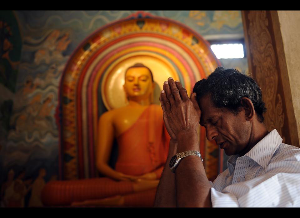 A Sri Lankan Buddhist devotee offers prayers at a temple in the Bellanvila suburb of Colombo as part of the traditional new year rituals.