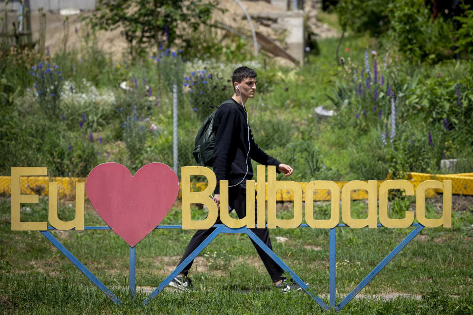 A man walks by a sign that reads "I love Bulboaca" outside the Castel Mimi, in Bulboaca, Moldova, Wednesday, May 31, 2023. Moldova will host the Meeting of the European Political Community on June 1, 2023. Preparations for a major summit of European leaders were still underway in Moldova on Wednesday, a sign of the Eastern European country’s ambitions to draw closer to the West and break with its Russian-dominated past amid the war in neighboring Ukraine. (AP Photo/Andreea Alexandru)