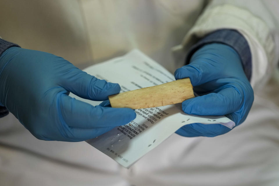 Doctor Vidak Simic who examined over 40 corpses of migrants and refugees retrieved from the river since 2017 shows bone sample taken from an unidentified body in Bijeljina, eastern Bosnia, Sunday, Feb. 4, 2024. In several cities along this river between Bosnia and Serbia, simple, durable gravestones now mark the final resting places of dozens of refugees and migrants who drowned in the area while trying to reach Western Europe. (AP Photo/Darko Vojinovic)