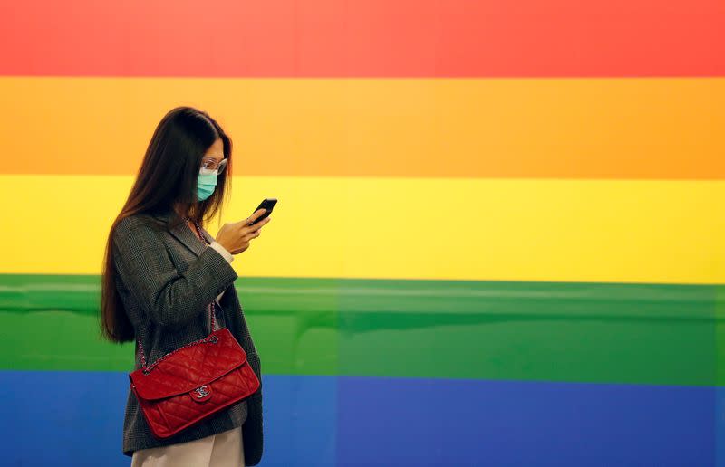 Woman in a face mask uses her phone in Porta Venezia subway in Milan