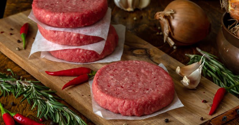 Raw beef burger, traditional barbecue, still life with vegetables and meat