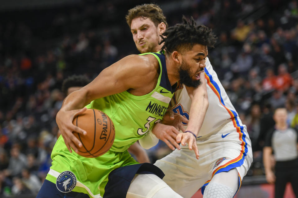 Minnesota Timberwolves center Karl-Anthony Towns collides with Oklahoma City Thunder forward Mike Muscala during the first half of an NBA basketball game Saturday, Jan. 25, 2020, in Minneapolis. (AP Photo/Craig Lassig)