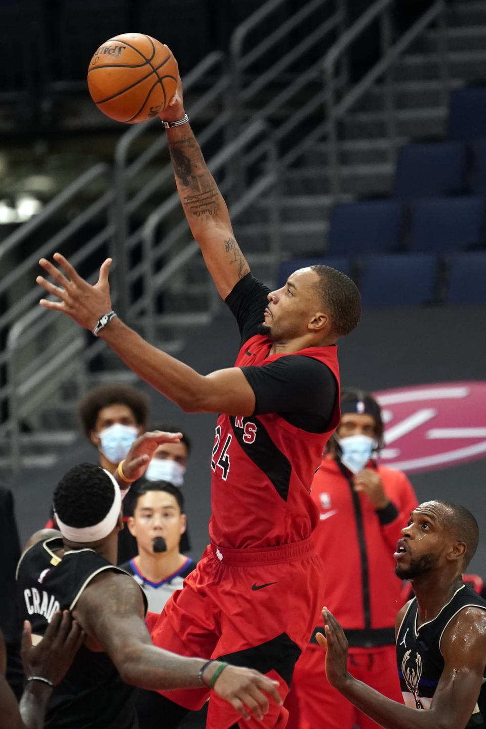 Toronto Raptors guard Norman Powell (24) shoots over Milwaukee Bucks forward Torrey Craig (3) and forward Khris Middleton (22) during the second half of an NBA basketball game Wednesday, Jan. 27, 2021, in Tampa, Fla. (AP Photo/Chris O'Meara)