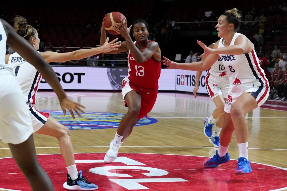 Canada's Shay Colley, centre, runs at France's Alexia Chartereau, right, and France's Lisa Berkani, left, during their game at the women's Basketball World Cup in Sydney, Australia, Friday, Sept. 23, 2022. (AP Photo/Mark Baker)