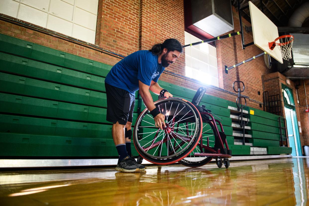 Justin Mathers gets his wheelchair ready during practice for the Fayetteville Flyers, an adaptive wheelchair basketball team, at Massey Hill Classical High School gym on Thursday, Aug. 19, 2023.