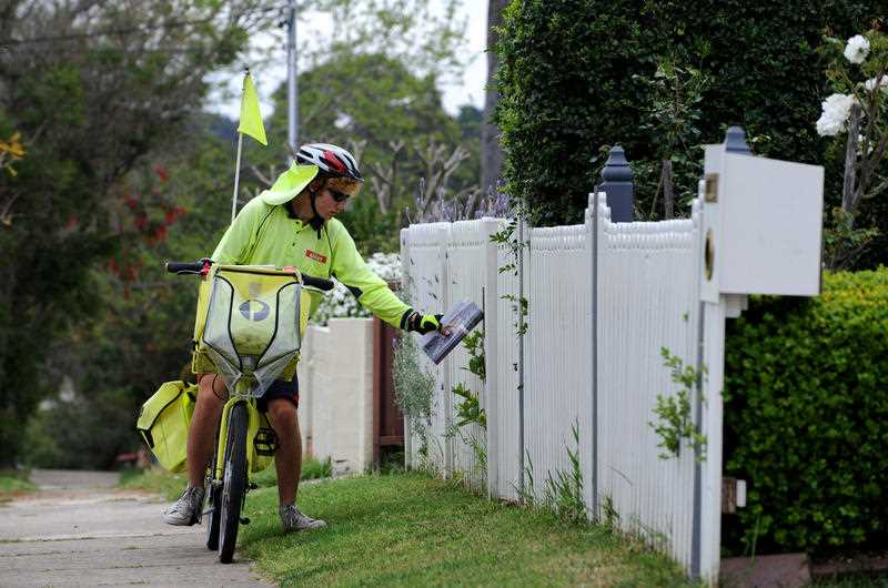 An Australia Post worker delivers mail by pushbike in suburban Sydney.