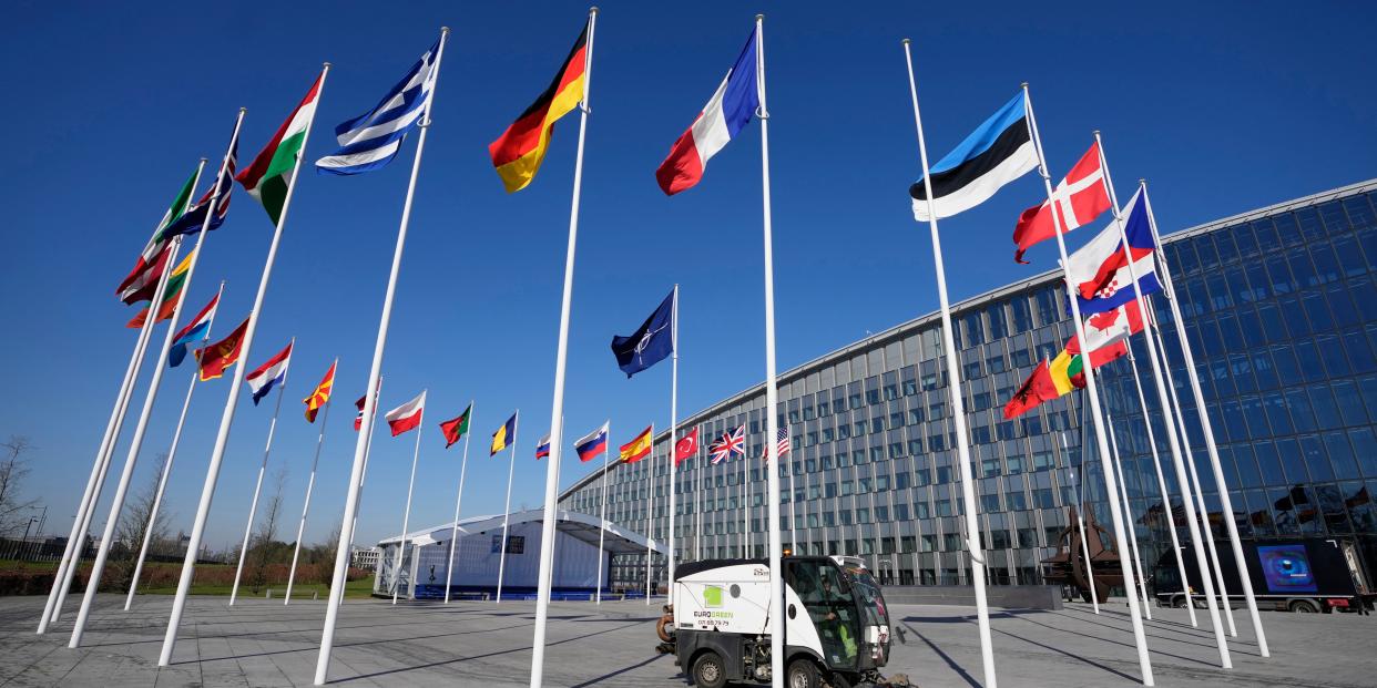 An empty flagpole stands between the national flags of France and Estonia outside NATO headquarters in Brussels, Monday, April 3, 2023.