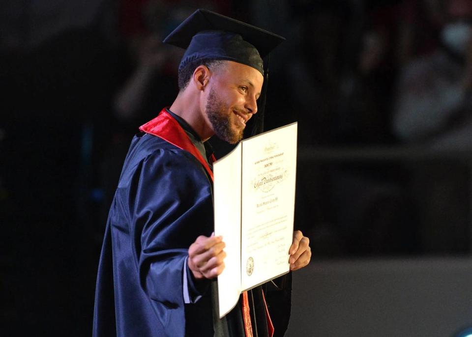 Stephen Curry shows his diploma to the audience at Davidson College on Aug. 31, 2022. In addition to receiving his diploma, Curry was inducted into the school’s hall of fame and also had his iconic number 30 jersey retired.