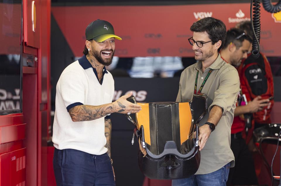 ARCHIVO - El cantante colombiano Maluma, izquierda, y Carlos Oñoro Sainz visitan el garage de Ferrari antes del comienzo del Gran Premio de Fórmula Uno en Miami en el Autódromo Internacional de Miami en Florida el 7 de mayo de 2023. A medida que el deporte aumenta su popularidad, las carreras de Fórmula Uno se han convertido en una oportunidad para mini festivales musicales. (Matias J. Ocner/Miami Herald via AP, archivo)