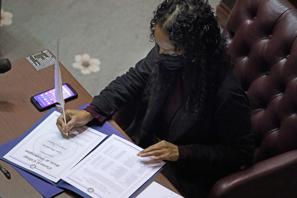 Democrat Sophia Danenberg, a member of Washington's Electoral College, fills in her ballot for Vice President-elect Kamala Harris at the state Capitol in Olympia, Wash., Monday, Dec. 14, 2020. (AP Photo/Ted S. Warren)