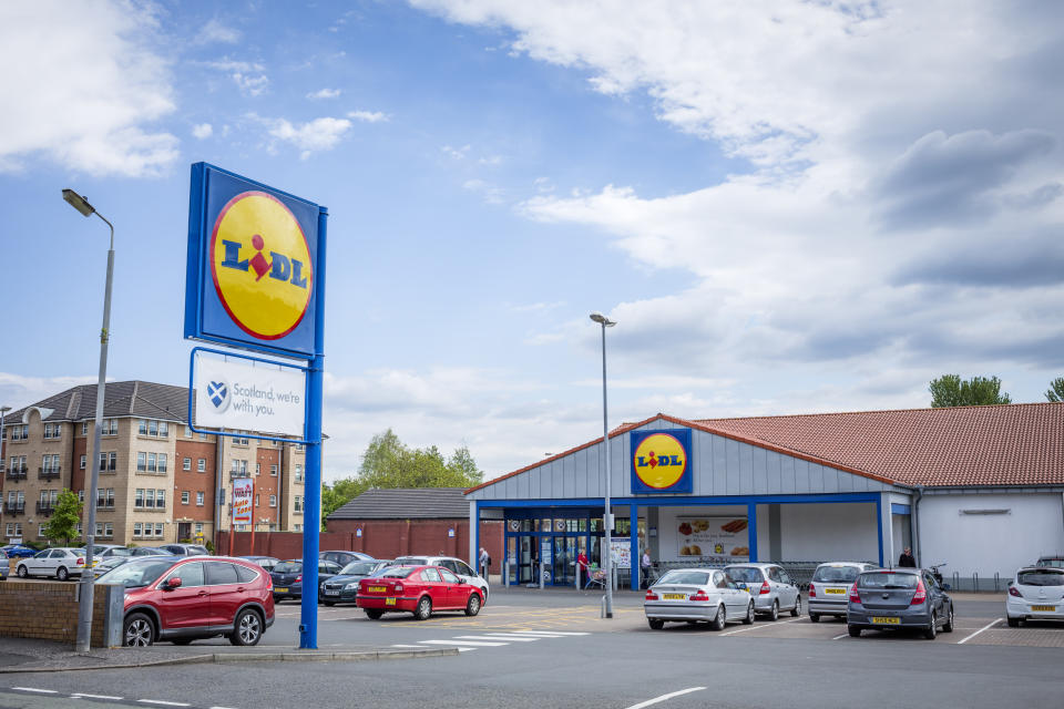 Glasgow, UK - May 30, 2013: Shoppers at the entrance and in the car park of a Lidl supermarket in the Pollockshaws area of Glasgow.