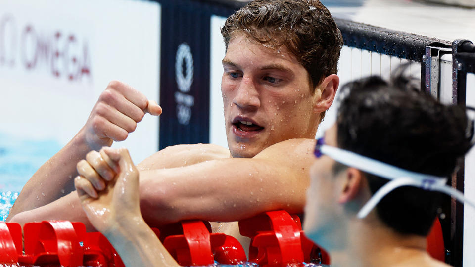 Brendon Smith fist-bumps a competitor after qualifying fastest for the 400m IM final at the Tokyo Olympics.