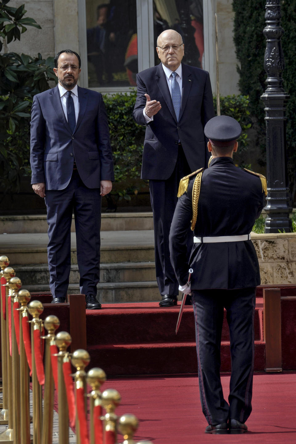 Cyprus' President Nikos Christodoulides, left, inspects the a guard of honor, with Lebanese caretaker Prime Minister Najib Mikati, right, upon his arrival to the government headquarters in Beirut, Lebanon, Monday, April 8, 2024. Christodoulides' visit to Beirut comes after he asked the European Union last week to intervene with Lebanese authorities to stop boatloads of Syrian refugees from heading to the east Mediterranean island nation. Lebanon's caretaker prime minister asked Southern European countries along the Mediterranean Sea to pressure the European Union to help Lebanon deport undocumented migrants. (AP Photo/Bilal Hussein)