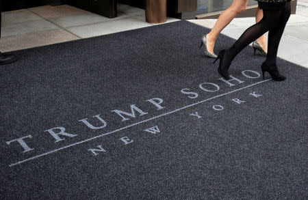 FILE PHOTO: Women walk across a carpet outside of the Trump Soho Hotel in New York, U.S. on April 9, 2010. The first Trump Hotel built in Downtown New York, a 46-story, 391-room luxury hotel condominium. REUTERS/Jessica Rinaldi/File Photo