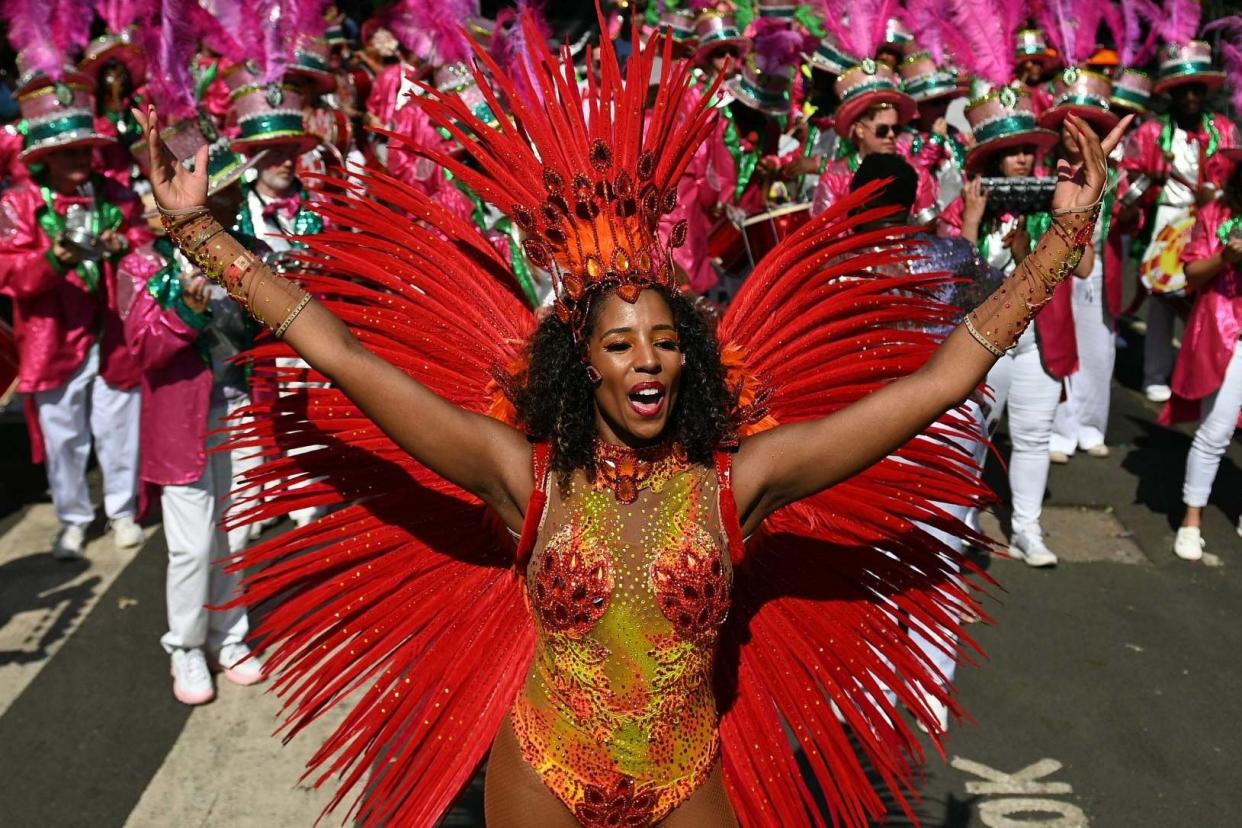 Celebration: masquerade performers lead festivities at Notting Hill Carnival yesterday: AFP/Getty Images