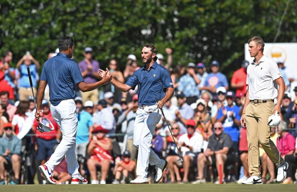 United States Team members Tony Finau, left and Max Homa, right, congratulate one another following Homa’s winning putt against the International Team during third round action of the Presidents Cup at Quail Hollow Club in Charlotte, NC on Saturday, September 24, 2022. At far right is International Team member Cam Davis looks on.