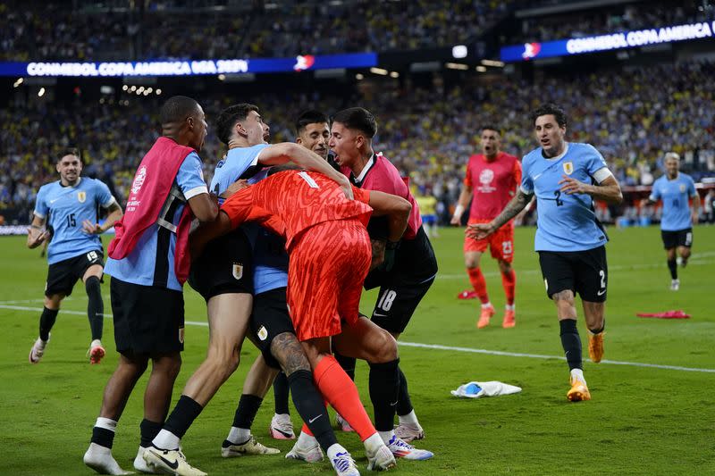 Jugadores de Uruguay se abrazan tras eliminar a Brasil en los cuartos de final de la Copa América