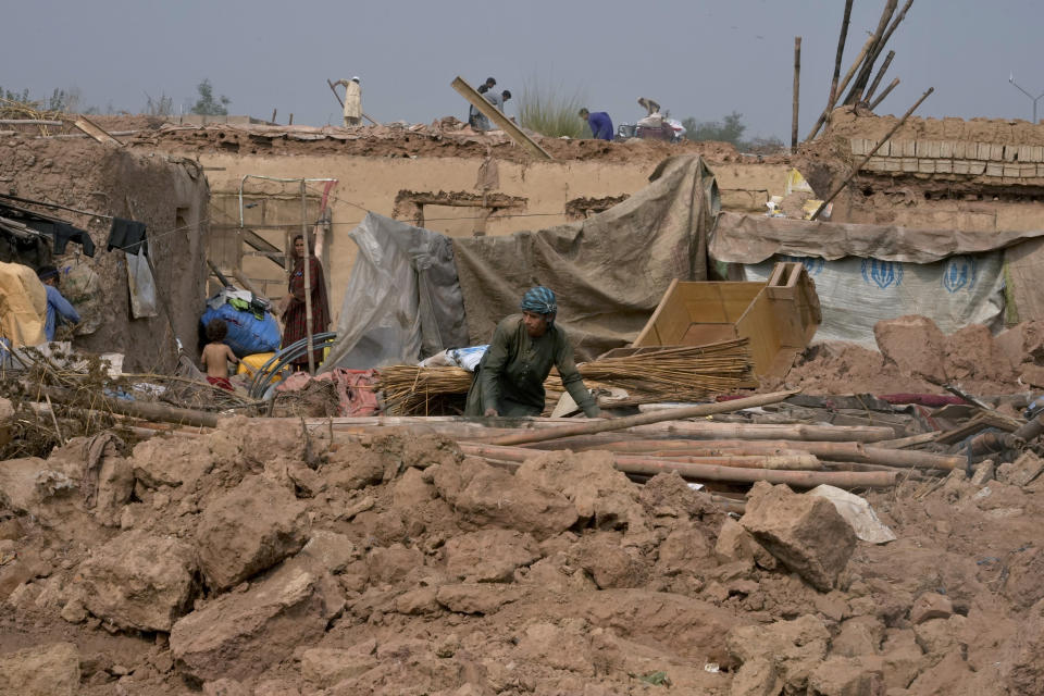 Afghans retrieve useful stuff from their damaged mud homes demolished by authorities during a crackdown against an illegal settlement and immigrants, on the outskirts of Islamabad, Pakistan, Wednesday, Nov. 1, 2023. (AP Photo/Anjum Naveed)