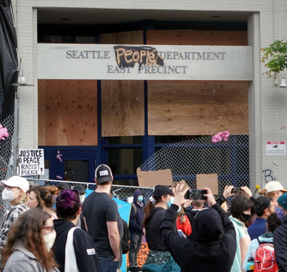 People take pictures of the Seattle Police Department's East Precinct building, which was renamed the Seattle People Department, during protests following the death of George Floyd in Minneapolis.