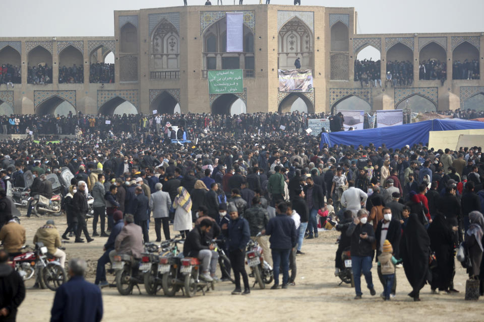 In this photo released by the semi-official Fars News Agency, farmers attend a protest demanding authorities open a dam to relieve drought-stricken areas of central province of Isfahan, on the dried up riverbed of the Zayandeh Roud river in the city of Isfahan 255 miles (410 kilometers) south of the capital Tehran, Iran, Friday, Nov. 19, 2021. Several prominent actors and athletes joined the peaceful movement, urging the government to intervene to aid famers increasingly suffering from droughts that have worsened over the years. The Khaju historical bridge is seen at rear. (Hamidreza Nikoomaram/Fars News Agency via AP)