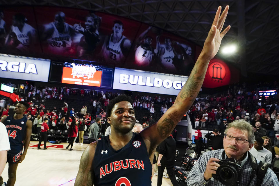 Auburn guard K.D. Johnson (0) waves to the crowd as he leaves the court following their win over Georgia in an NCAA college basketball game Saturday, Feb. 5, 2022, in Athens, Ga. (AP Photo/John Bazemore)