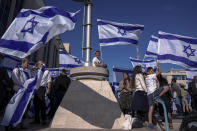 Israeli right wing activists with Israeli flags gather for a march in Jerusalem, Wednesday, April 20, 2022. A group of Israeli ultra-nationalists said it is determined to go ahead with a flag-waving march around predominantly Palestinian areas of Jerusalem's Old City, brushing aside a police ban of an event that served as one of the triggers of last year's Israel-Gaza war. (AP Photo/Ariel Schalit)