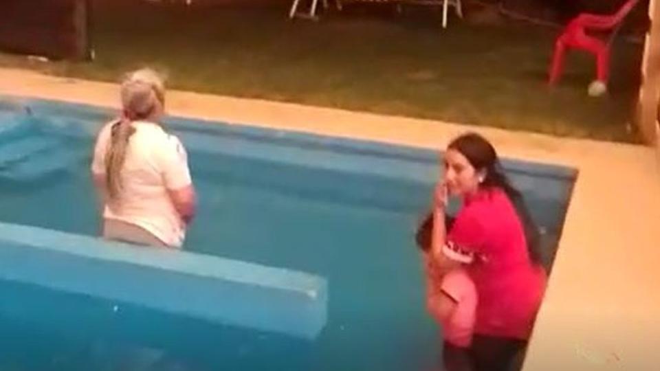 Dos mujeres y una niña se refugian en una piscina