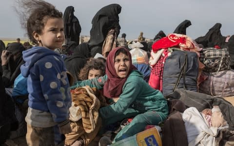 Civilians fleeing from isil's last remaining territory in Syria after two days of heavy fighting wait at a gathering point where before being taken to internment camp, near Baghuz - Credit: Sam Tarling