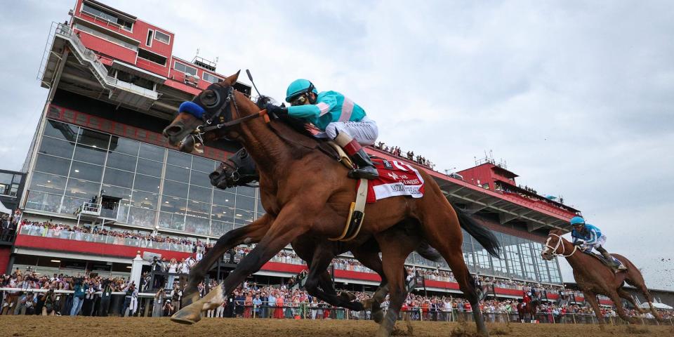 Jockey John Velazquez #1 riding National Treasure (front) rides alongside jockey Irad Ortiz Jr. #7 riding Blazing Sevens (to cross the finish line first to win the 148th Running of the Preakness Stakes.