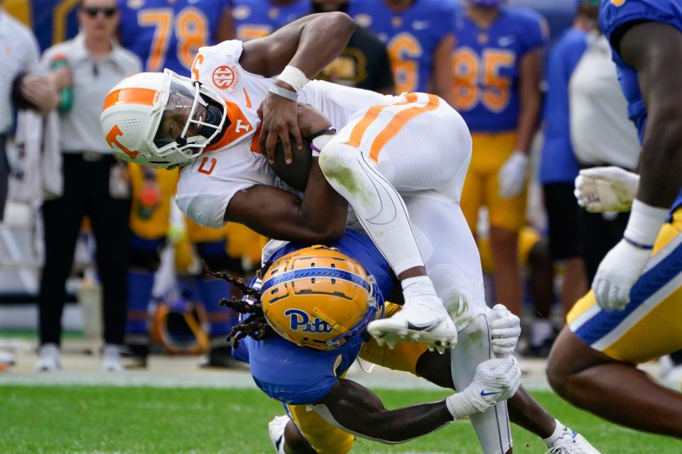 Pittsburgh defensive back Brandon Hill (9) tackles Tennessee quarterback Hendon Hooker (5) as he scrambles during the first half of an NCAA college football game, Saturday, Sept. 10, 2022, in Pittsburgh. (AP Photo/Keith Srakocic)