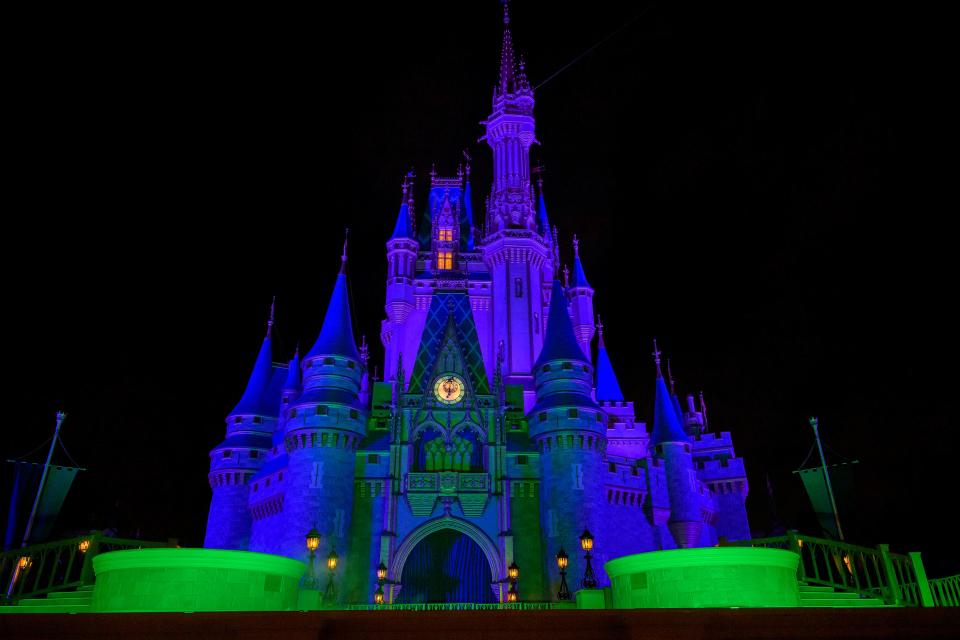 Cinderella's castle is decked out for Halloween in the style of the Haunted Mansion, the classic attraction that thrills foolish mortals at Magic Kingdom.