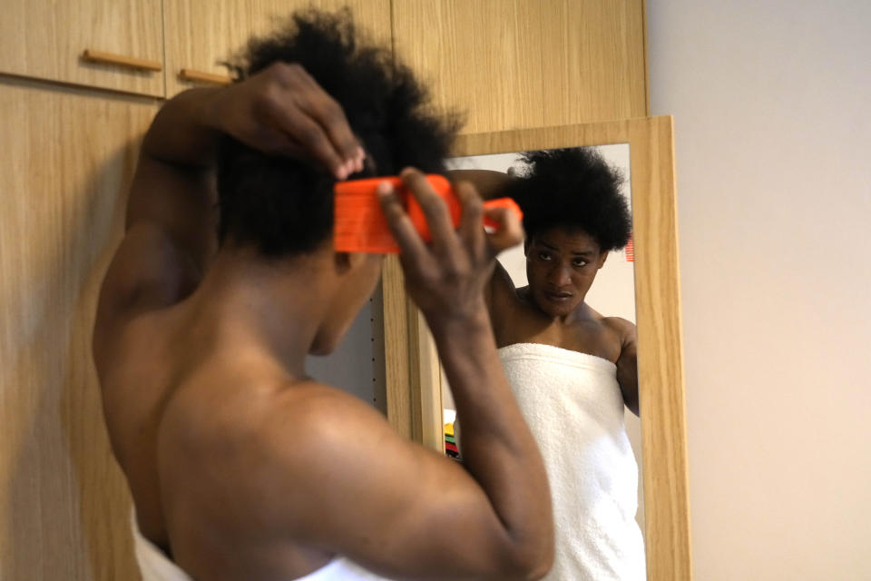 Guinean wrestler Fatoumata Yarie Camara adjusts her hair in her room of the Ostia's Olympic training center, near Rome, Monday, July 5, 2021. A West African wrestler's dream of competing in the Olympics has come down to a plane ticket. Fatoumata Yarie Camara is the only Guinean athlete to qualify for these Games. She was ready for Tokyo, but confusion over travel reigned for weeks. The 25-year-old and her family can't afford it. Guinean officials promised a ticket, but at the last minute announced a withdrawal from the Olympics over COVID-19 concerns. Under international pressure, Guinea reversed its decision. (AP Photo/Alessandra Tarantino)