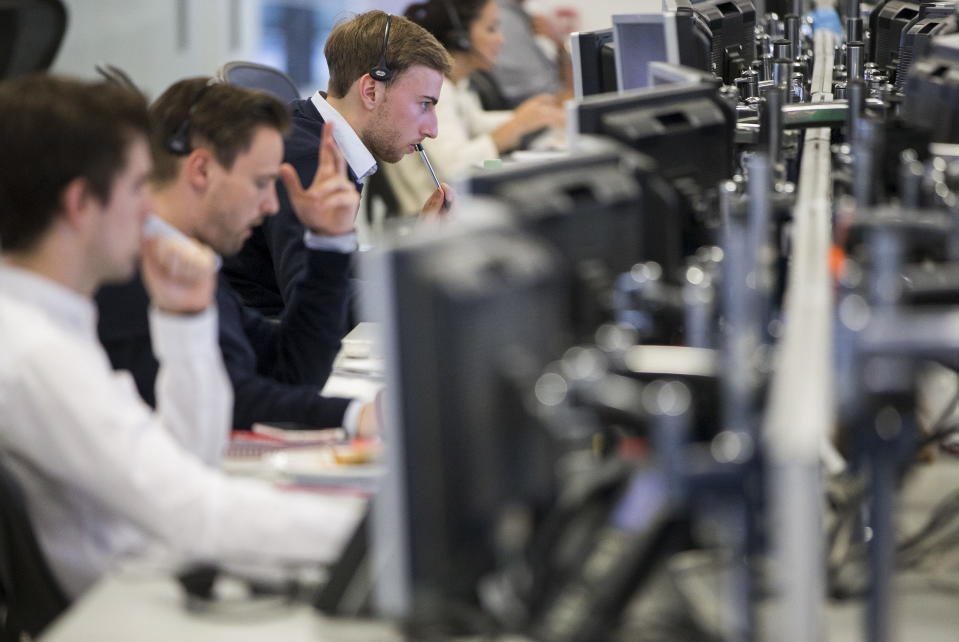 Dealers work on the IG Group trading floor in London, Britain June 30, 2015. Euro zone stocks and low-rated bonds recovered the worst of their losses on Tuesday but remained on edge as Greece looked set to default on a debt repayment to the IMF and plunge deeper into financial crisis. REUTERS/Neil Hall