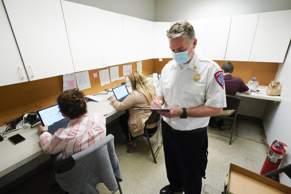 Sterling Heights Fire Department Chief Kevin Edmond works at a vaccine distribution location in Sterling Heights, Mich., Wednesday, April 28, 2021. While staffing levels in his department have remained the same since the mid-1990s, the number of runs the department makes for various emergencies has increased from 5,000 annually to more than 16,000. “A lot of people are using EMS as their primary health care providers,” often because they have no insurance, Edmond said. (AP Photo/Paul Sancya)