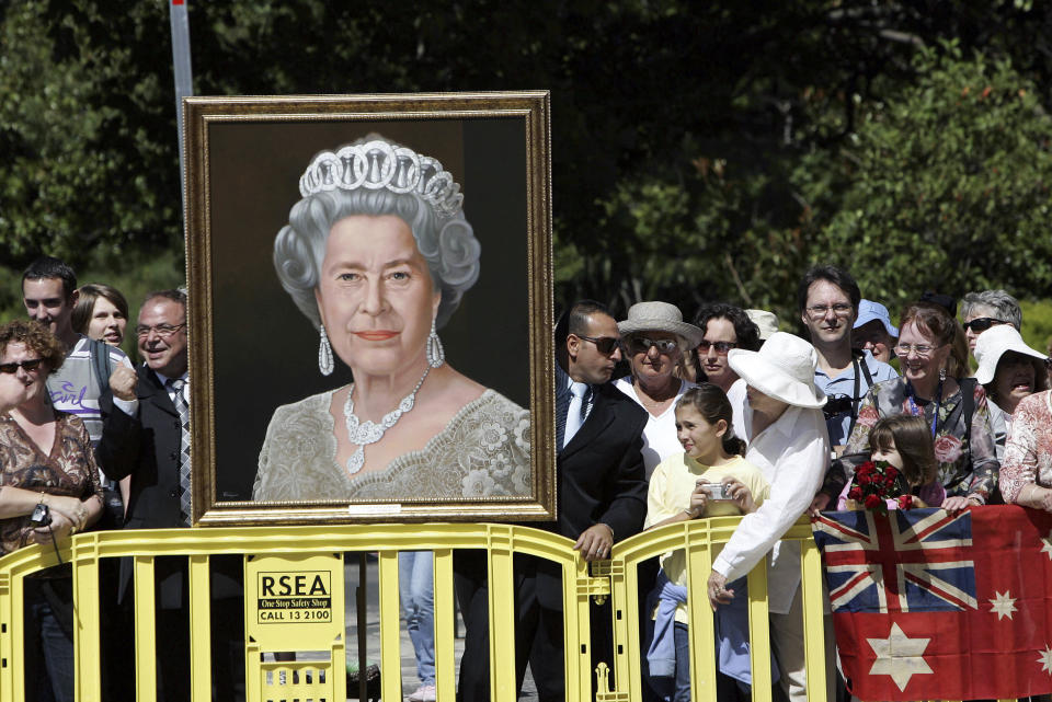 Wellwishers holding a portrait of Britain's Queen Elizabeth II wait for her arrival in Melbourne, Australia, March 15, 2006. (AP Photo/Rick Stevens)